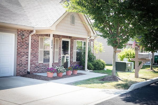 The entryway of Brownsburg Meadows Assisted Living with colorful flower pots.