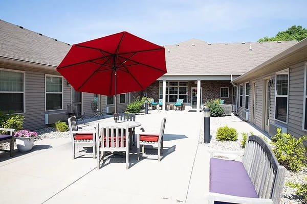 Outdoor patio with tables and umbrellas at Brownsburg Meadows Assisted Living