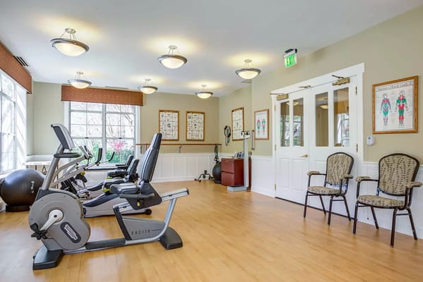 Indoor fitness area with exercise equipment and seating at Byron Park.