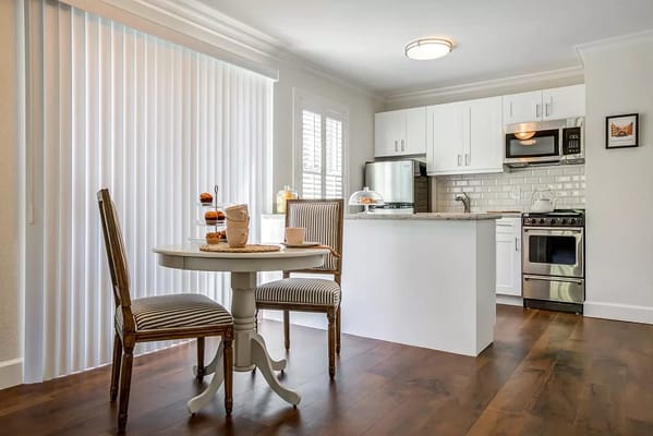 Cozy dining area with a round table and two chairs in a well-lit kitchen