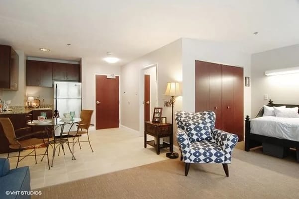Interior view of a resident living space with a bed and seating area