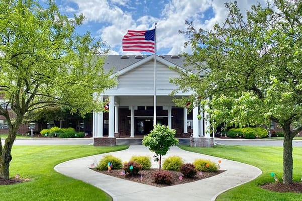 Front entrance of a senior living facility with flags