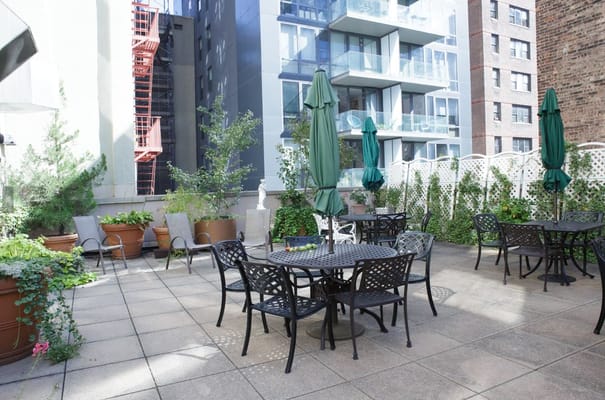 Outdoor patio area with tables and green umbrellas