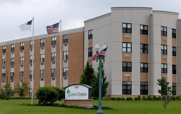 Exterior view of a senior living facility with flags