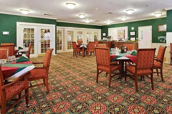 Dining room with green walls and ornate carpet