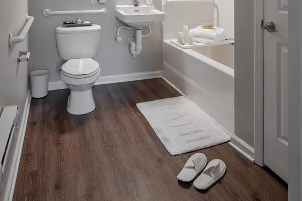A clean and accessible bathroom with a toilet, sink, and bathtub