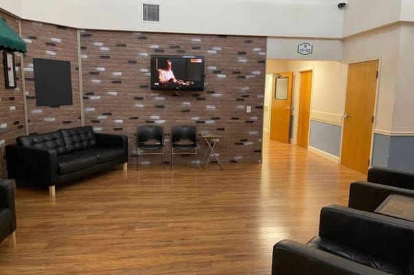 Lounge area with black couches and television in Cloudberry Lodge.