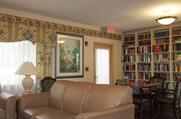 Lounge area featuring a sofa, lamp, and bookcase