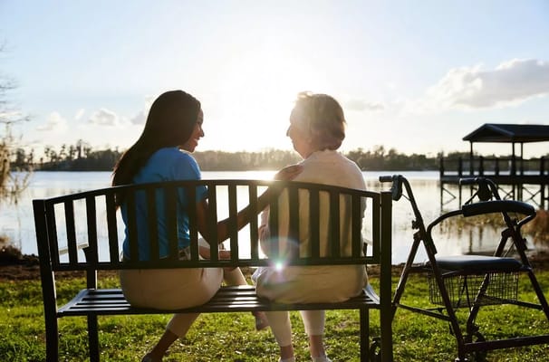 A caregiver and a senior relaxing by the lake