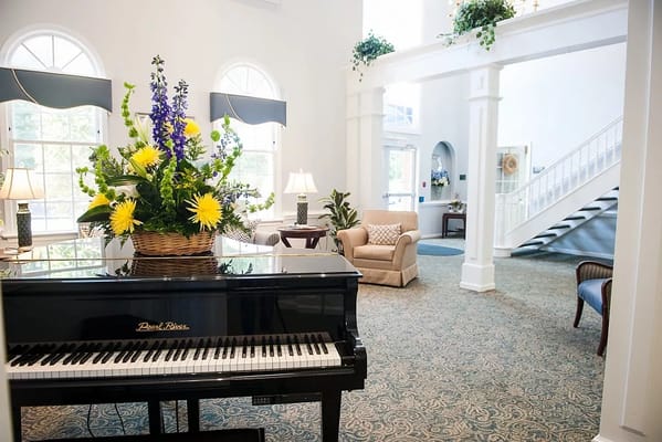 Interior view of a beautifully decorated lobby with a piano and flowers
