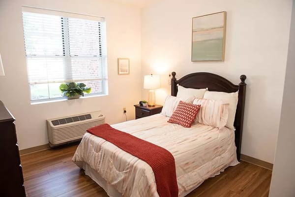 A cozy resident room with a bed and window