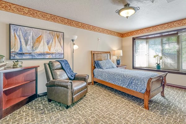 Private resident room with a bed and chair