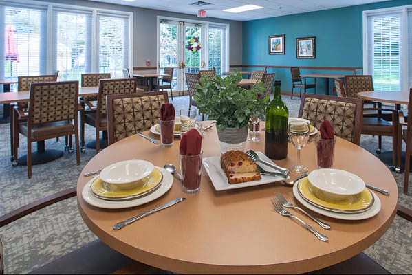 Table set for dining in the facility's dining room with food and drinks.