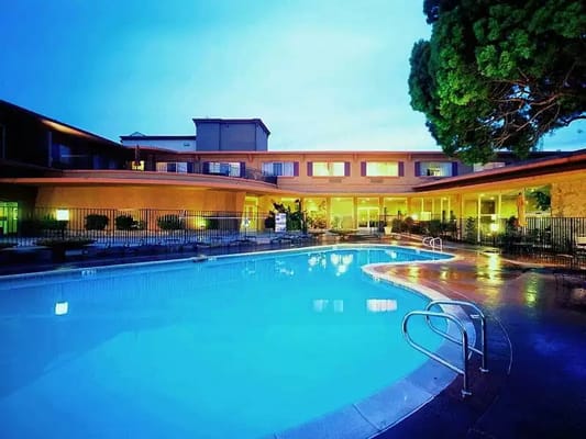 Outdoor swimming pool at The Villa at San Mateo Apartments during twilight