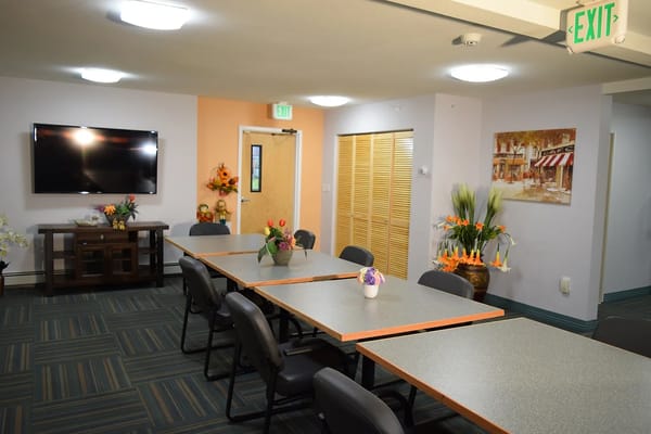 Bright activity room with tables and a television