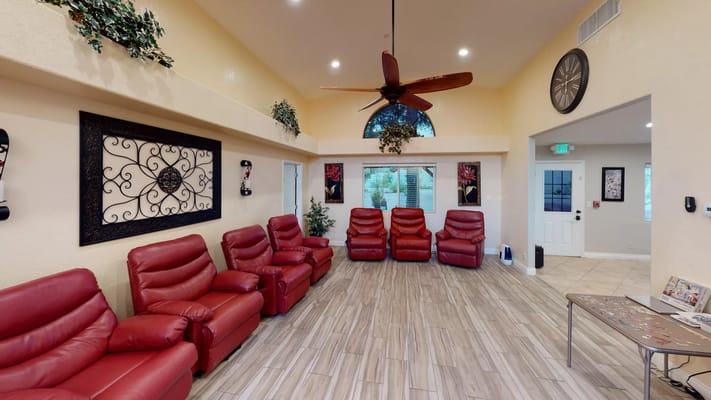 Cozy lounge area with red recliners and a high ceiling