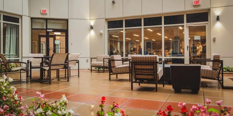 Outdoor seating area with flowers and people visible