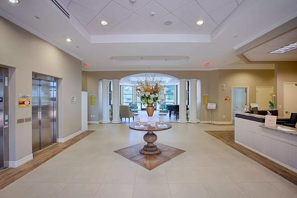 Lobby area with elevator, reception desk, and floral arrangement