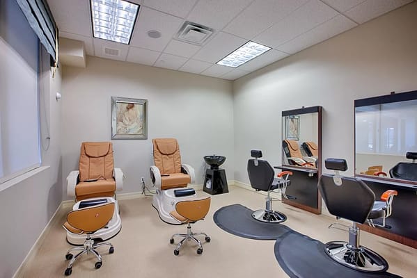Interior of a spa room with comfortable seating and mirrors.