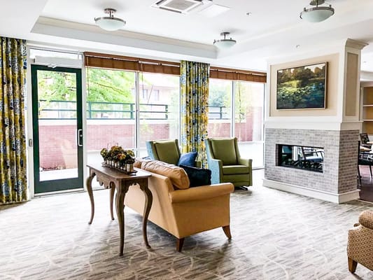 Bright lounge area with seating and a fireplace