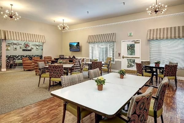 Common area with tables and chairs in a bright setting