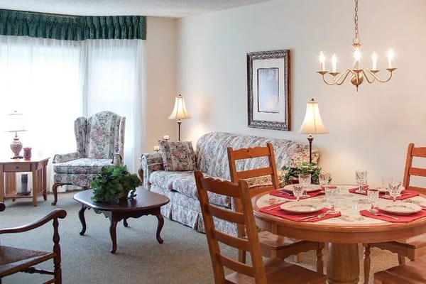 A cozy living room and dining area with floral decor and soft lighting.