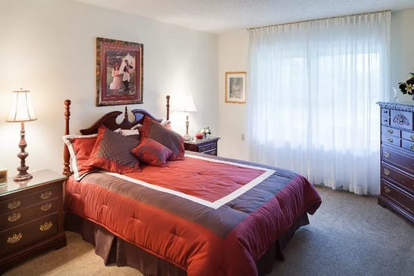 Comfortable bedroom with a large bed, two lamps, and a window