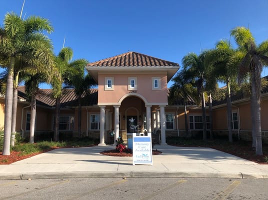 Front entrance of Gulf Coast Memory Care with palm trees and a sign.