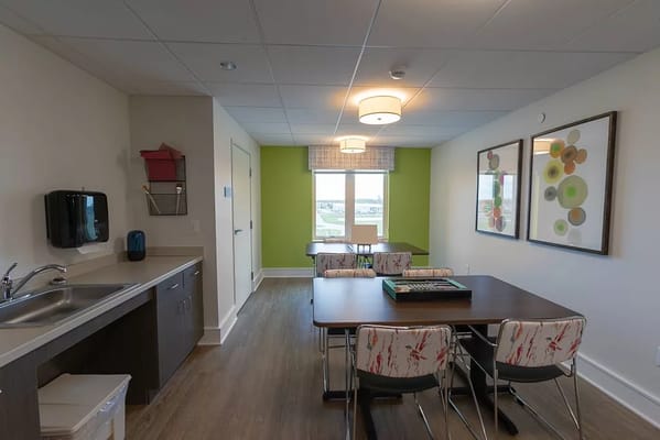 Modern common area with dining table and kitchen sink.