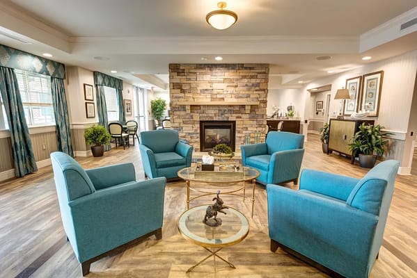 A cozy lounge area with blue chairs and a stone fireplace