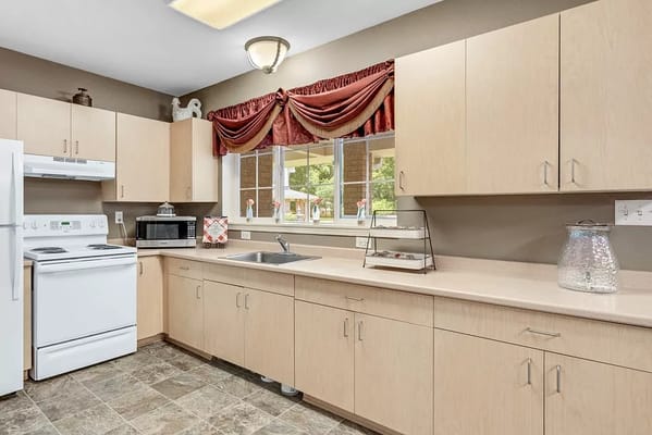Bright kitchen area with wooden cabinets and appliances