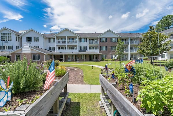 Exterior view of a senior living facility with gardens