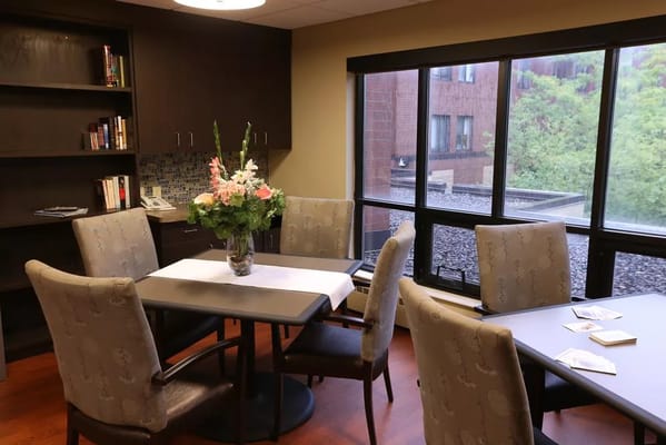 Bright dining area with a table and floral arrangement.