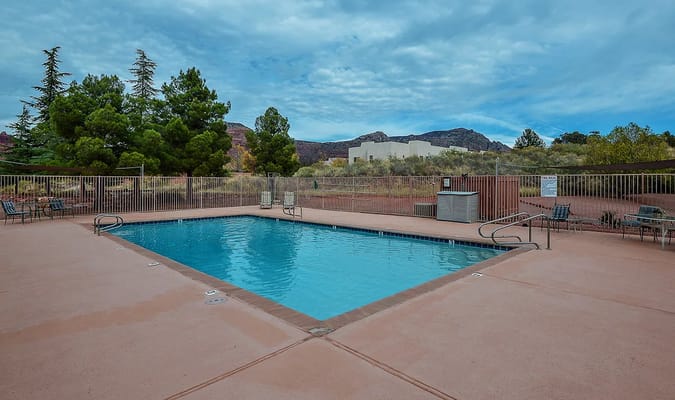 Swimming pool area with mountain backdrop and trees