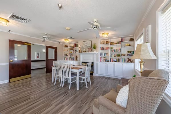 A cozy interior common area with bookshelves and seating