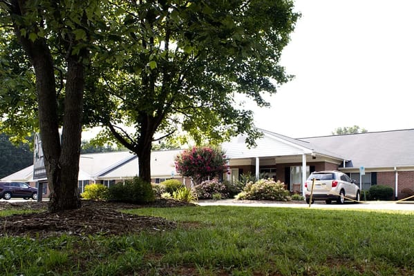 Exterior view of assisted living facility surrounded by trees