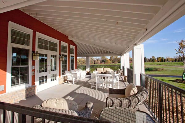 Outdoor seating area with tables and chairs overlooking green space