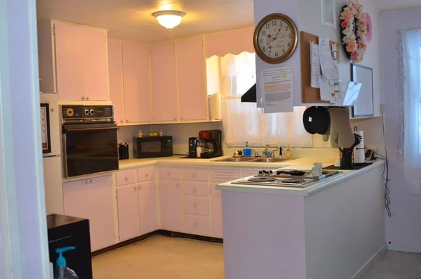 Spacious kitchen with pink cabinets and appliances