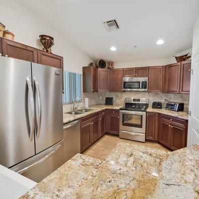 Spacious kitchen with stainless steel appliances and granite countertops.
