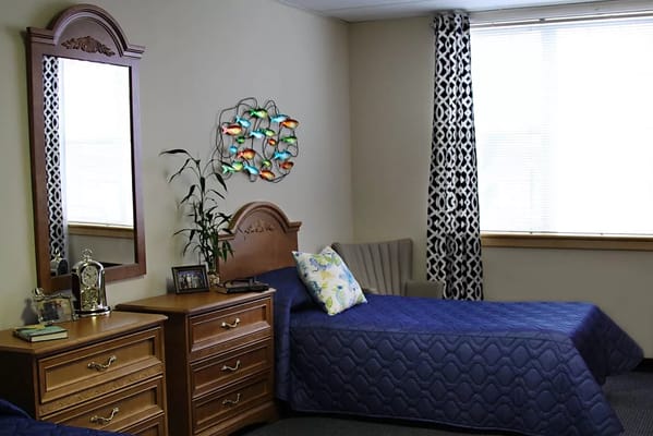 Cozy resident room with two beds and decorative mirror