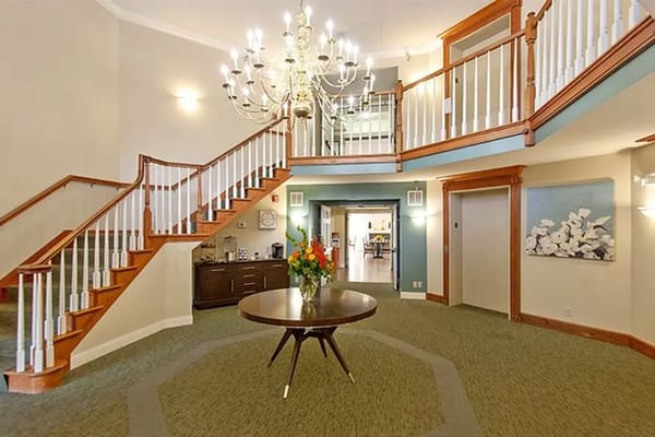 Spacious lobby with chandelier and staircase at LakeHouse Menomonee.
