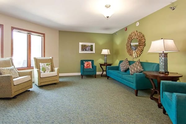 Bright living room with teal furniture and large windows