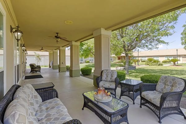 Covered porch area with seating and greenery