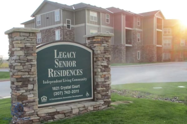 Sign of Laramie Senior Housing featuring stone pillars and text