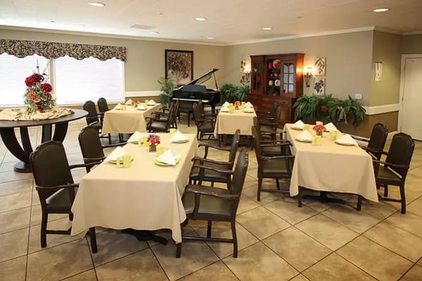 Brightly lit dining room with tables set for meals