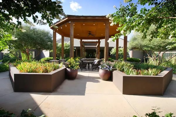 Outdoor seating area surrounded by lush greenery at Legacy Ranch.