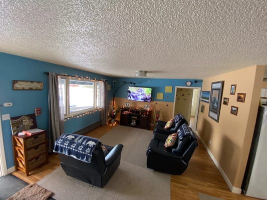 Comfortable living room with seating, a TV, and decorative elements.