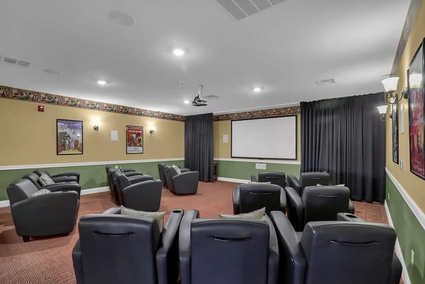 Theater room with seating and a projection screen
