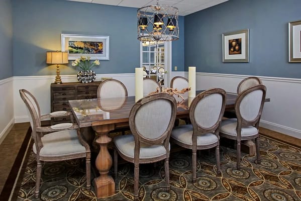 A bright dining room with a large wooden table and elegant decor