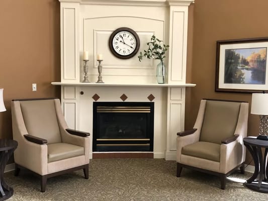 Cozy lounge area with two chairs and a fireplace